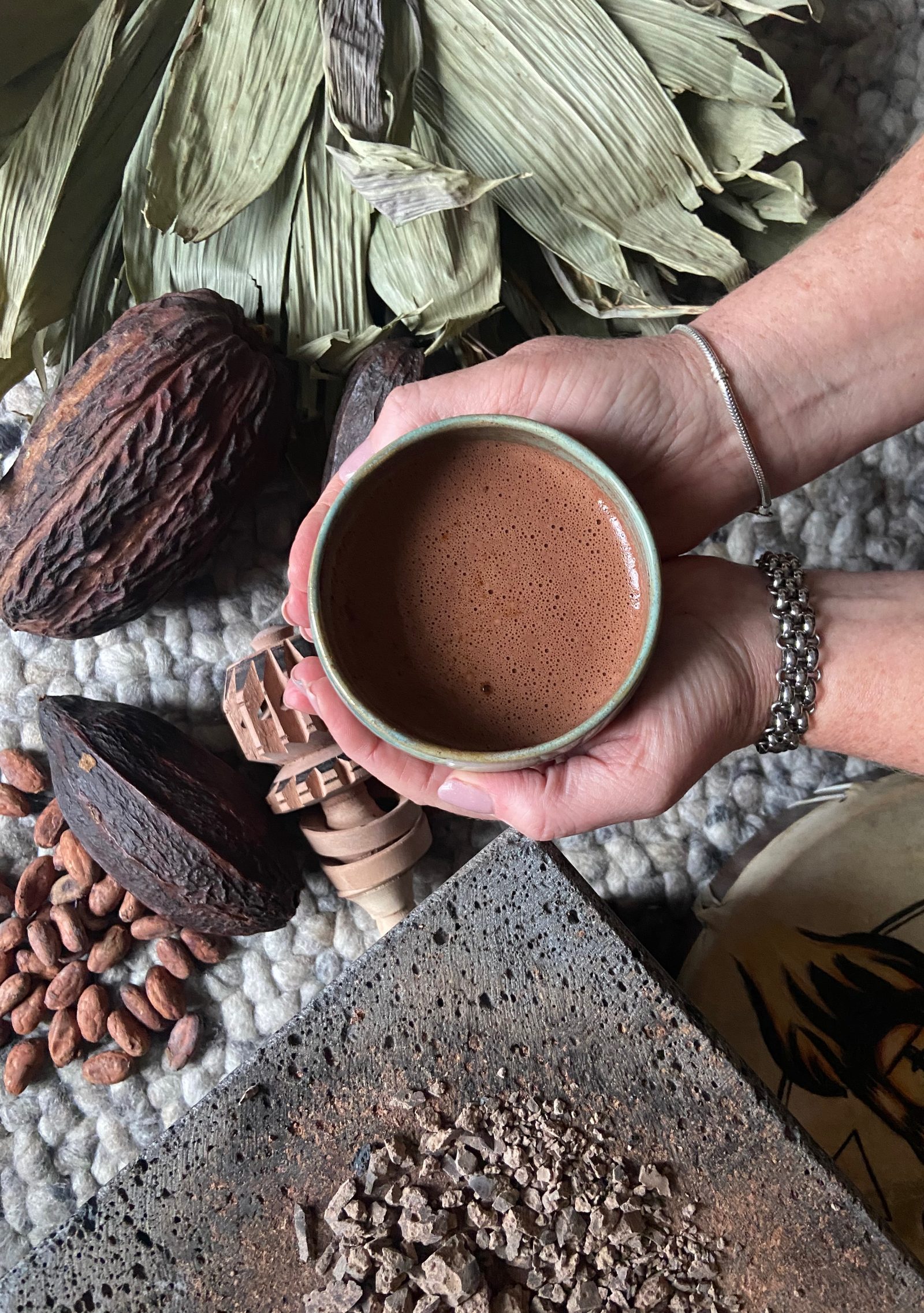 Cacao facilitation — handen met een kop ceremoniële cacao